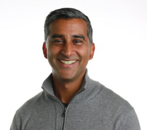 person in grey sweater smiling